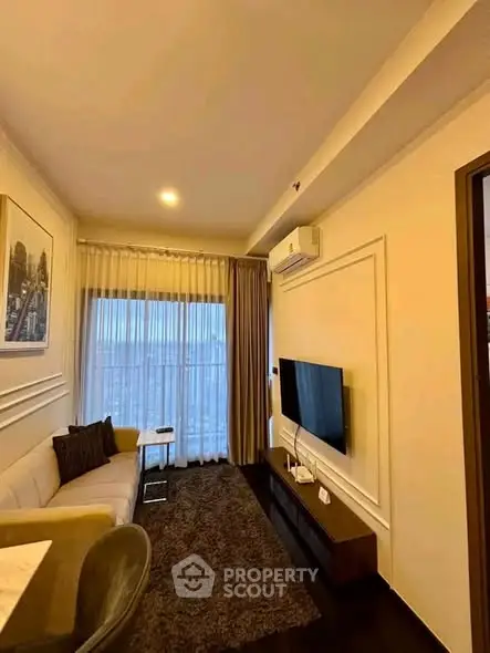 Modern living room with sleek design, featuring a wall-mounted TV, cozy sofa, and elegant decor.