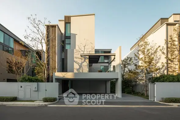 Modern multi-story residential building with sleek design and spacious driveway.