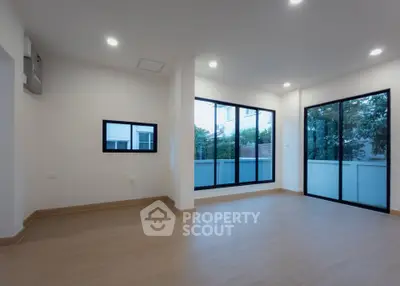 Spacious modern living room with large windows and wooden flooring