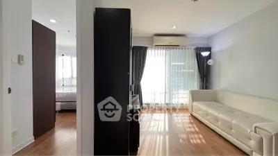 Spacious living room with natural light and modern furnishings in a stylish apartment.