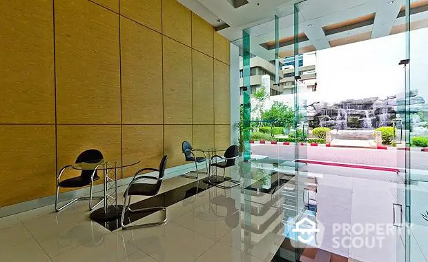 Modern building entrance with glass walls and stylish seating area