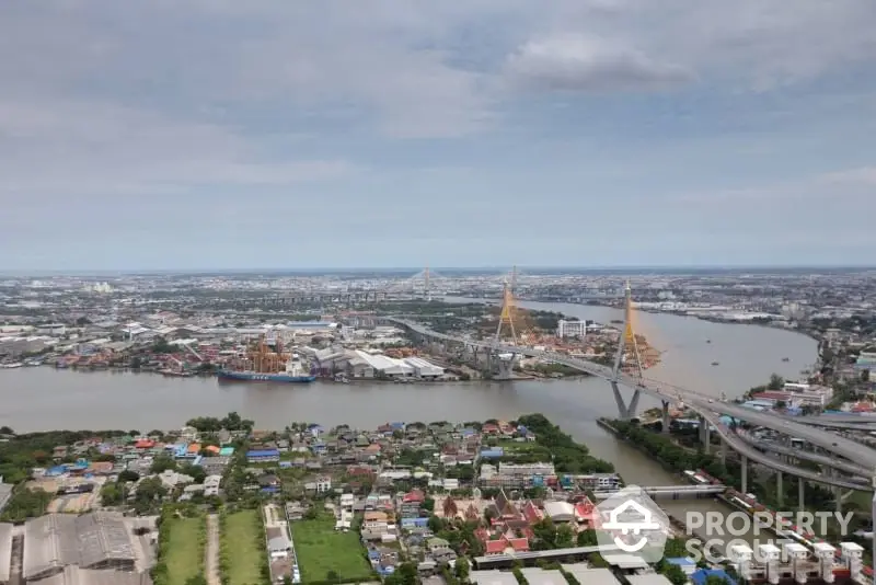 Stunning aerial view of cityscape with iconic bridge and river, showcasing urban development and connectivity.