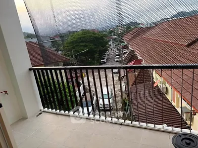 Charming balcony with scenic view of rooftops and lush greenery, perfect for relaxation.