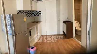 Compact kitchen with modern appliances and adjacent bathroom in cozy apartment.