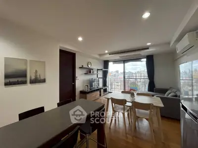 Modern open-plan living room with dining area and city view