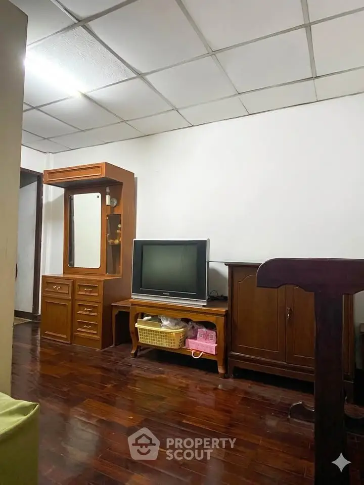 Cozy living room with vintage wooden furniture and classic TV setup.