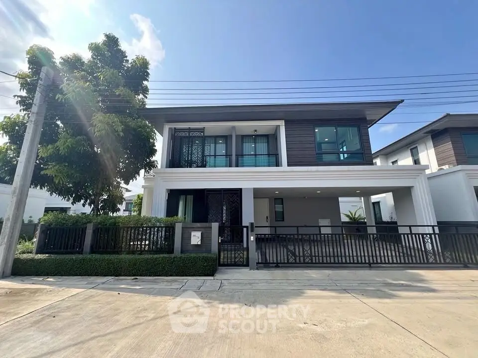 Modern two-story house with sleek design and spacious driveway in a serene neighborhood.