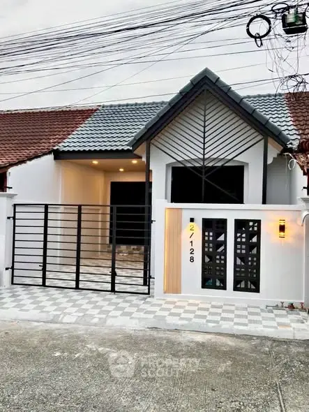 Charming single-story house with modern facade and gated entrance