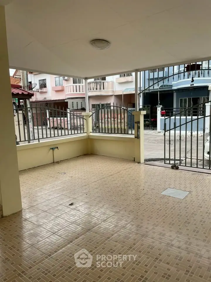 Spacious covered parking area with tiled flooring in a residential neighborhood.