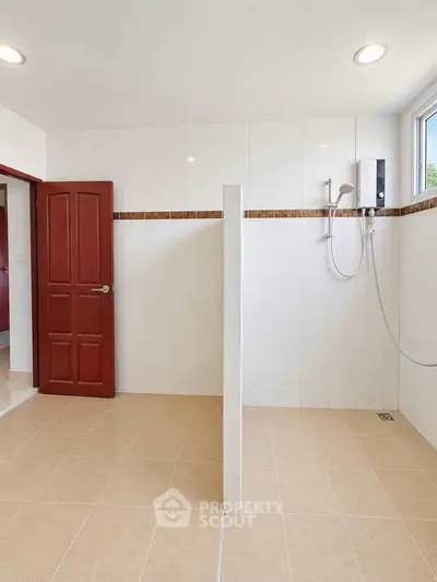 Spacious bathroom with modern shower and tiled walls in a bright, airy home.