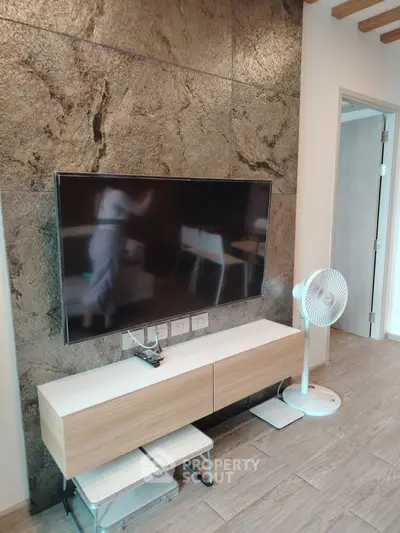 Modern living room with wall-mounted TV and stylish wooden cabinet