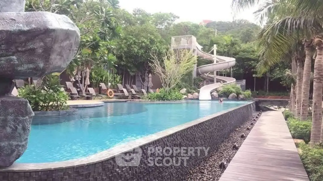 Luxurious outdoor pool with slide and lush greenery, perfect for relaxation and leisure.