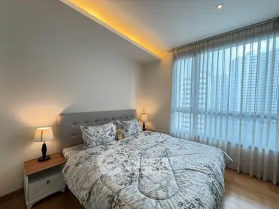 Cozy bedroom with large window and elegant decor in modern apartment