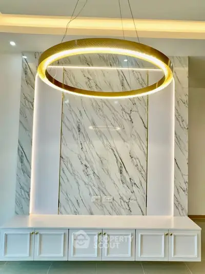 Luxurious modern interior with elegant marble wall and stylish lighting fixture.