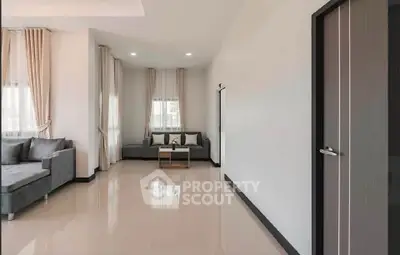Spacious modern living room with elegant gray sofas and large windows.