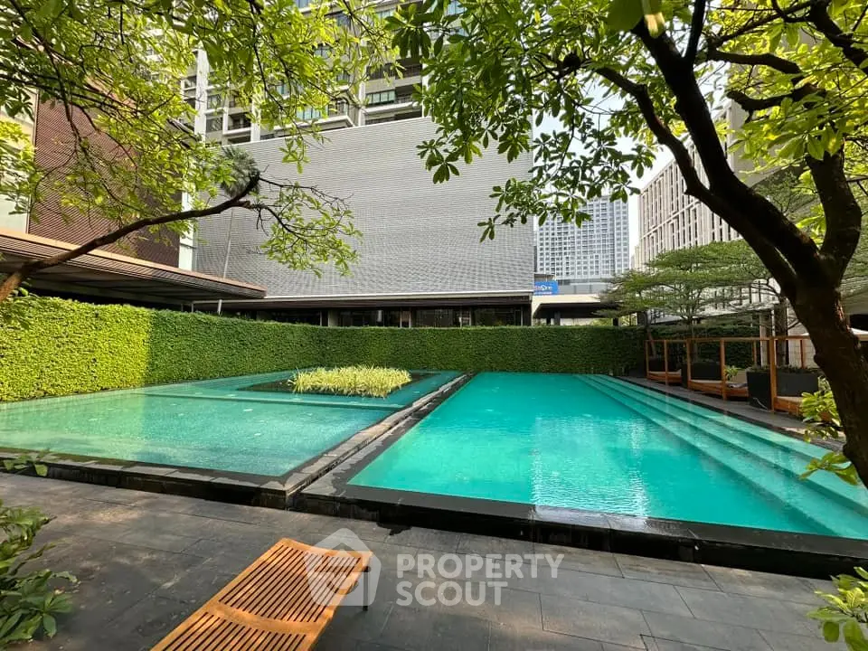 Luxurious outdoor pool area with lush greenery and modern design, perfect for relaxation and leisure.