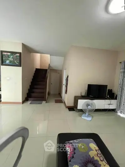 Spacious living room with modern decor and staircase in a cozy home.