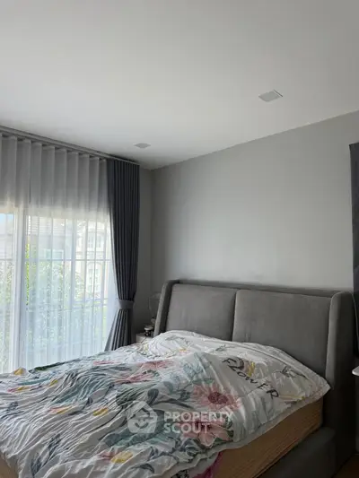 Cozy bedroom with modern decor and large window for natural light