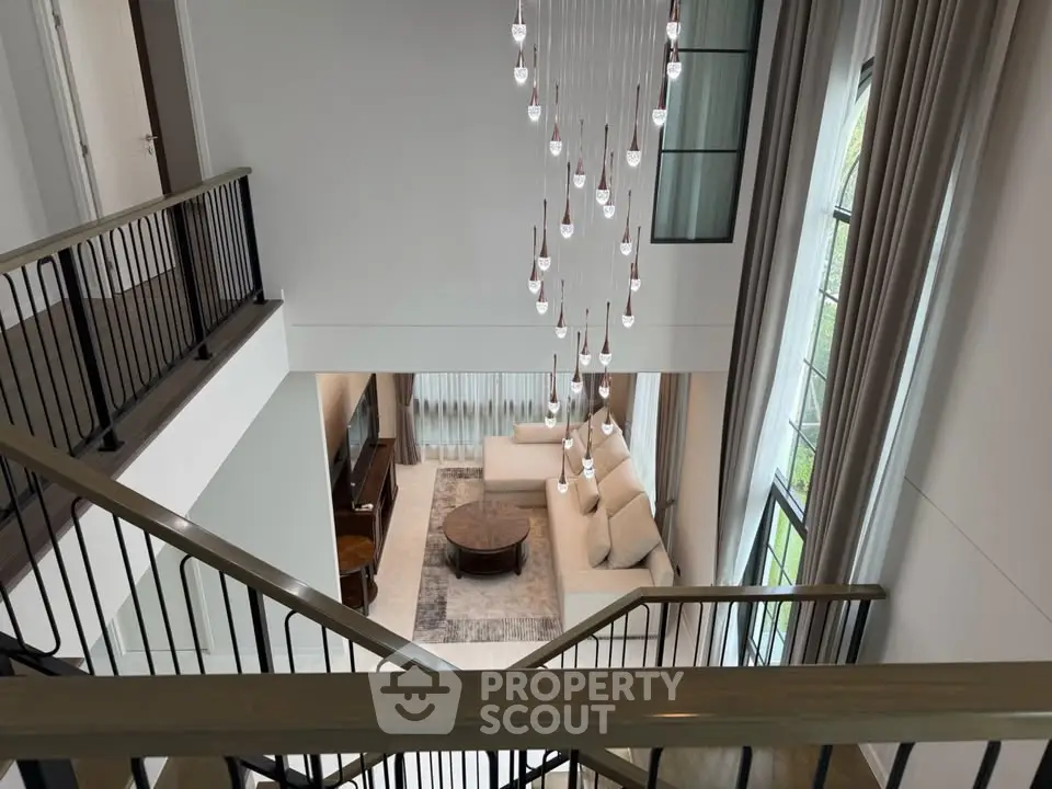Luxurious living room with high ceiling and elegant chandelier view from staircase