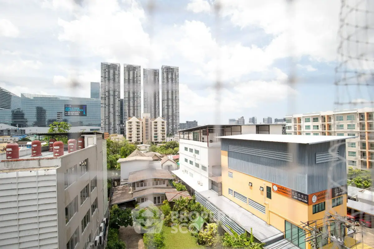 Stunning cityscape view from a high-rise building showcasing modern architecture and lush greenery.