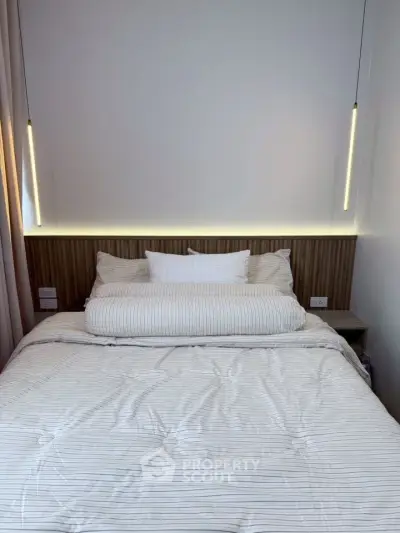 Modern bedroom with stylish lighting and cozy bedding