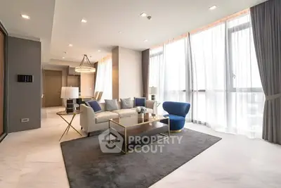 Luxurious modern living room with elegant furniture and large windows.