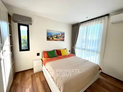 Bright and cozy bedroom with large window and colorful decor in modern apartment.