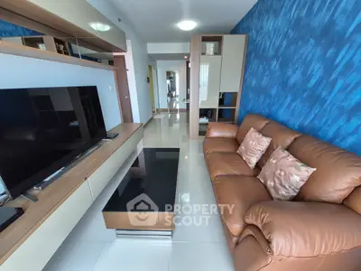 Modern living room with leather sofa and sleek entertainment unit in stylish apartment.