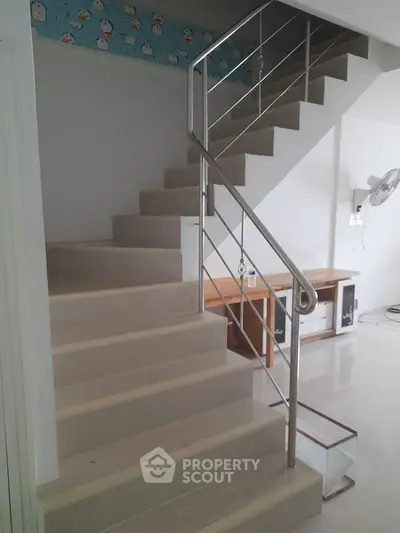 Modern staircase with sleek metal railing in a bright interior space
