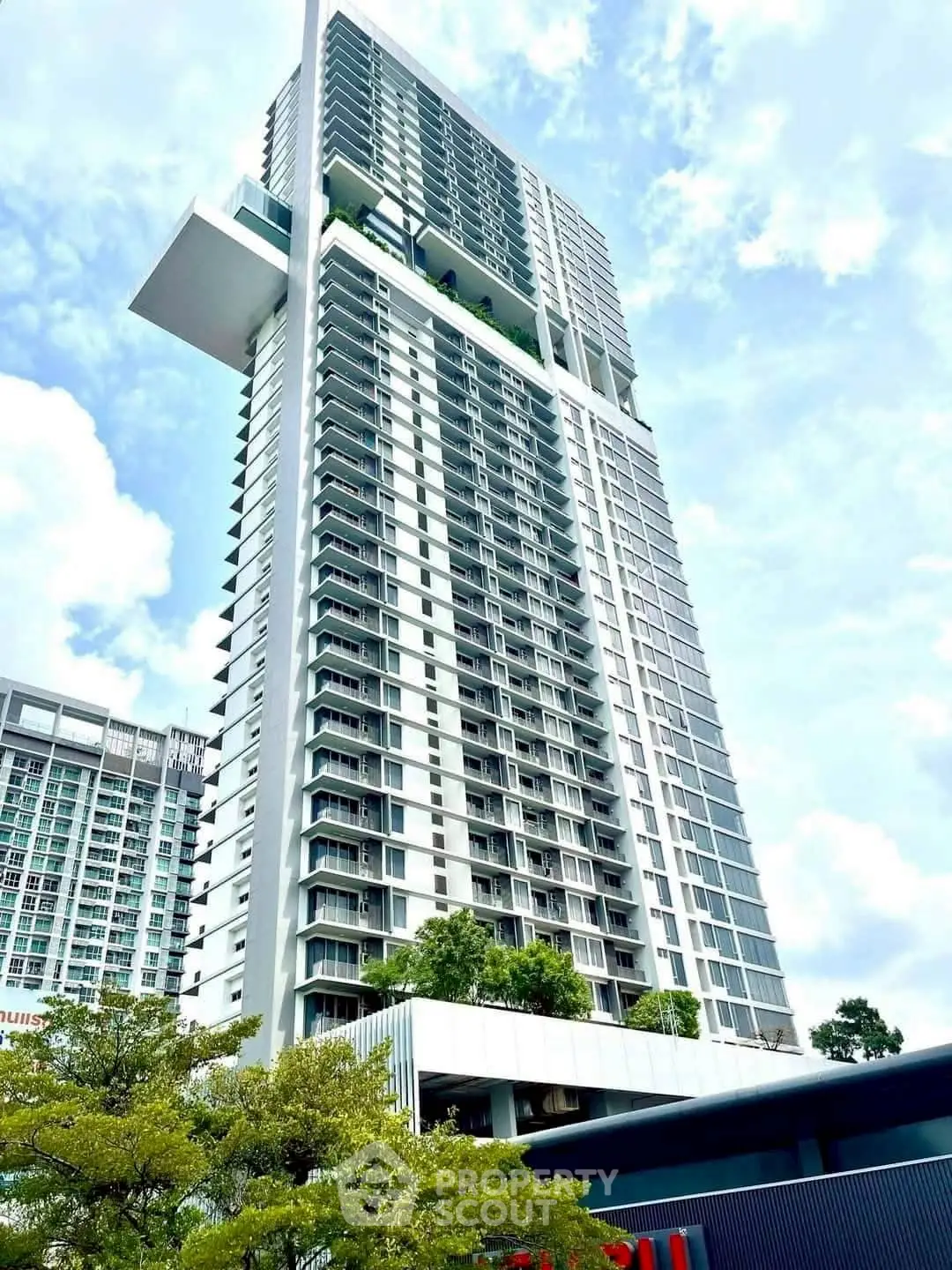 Stunning modern high-rise building with lush greenery and sky garden, perfect for urban living.