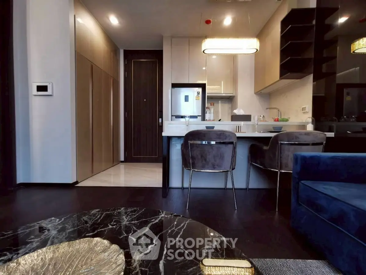 Modern kitchen with sleek design, marble table, and stylish seating in a contemporary apartment.