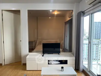 Modern living room with large window and city view, featuring sleek furniture and natural light.