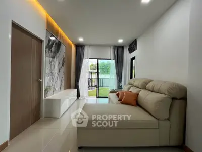 Modern living room with elegant sofa and large window offering garden view