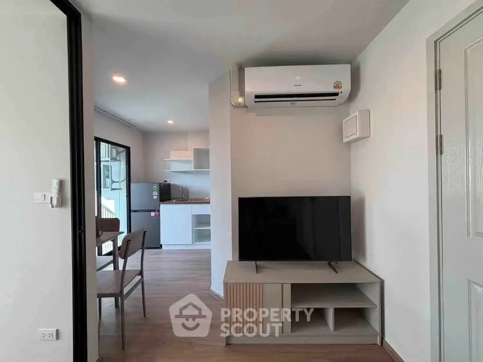 Modern living room with air conditioning and open kitchen layout in a stylish apartment.
