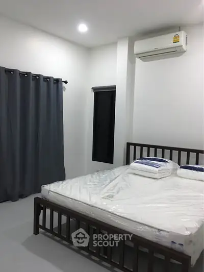 Modern bedroom with minimalist design and air conditioning unit