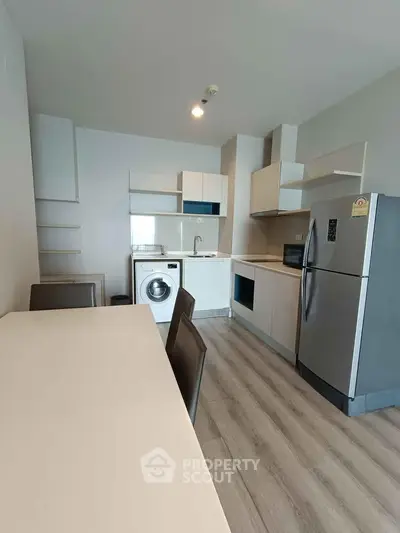 Modern kitchen with sleek appliances and dining area in a stylish apartment.