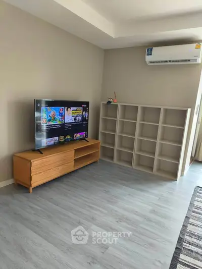 Modern living room with sleek TV stand and air conditioning, perfect for cozy entertainment.