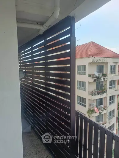 Charming balcony with privacy screen and city view in modern apartment