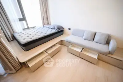 Modern minimalist bedroom with platform bed and sofa, featuring built-in storage drawers.