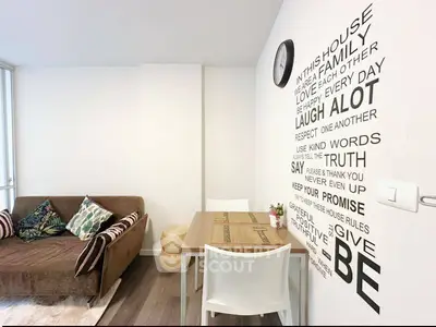 Cozy living room with stylish wall art and comfortable seating in modern apartment.
