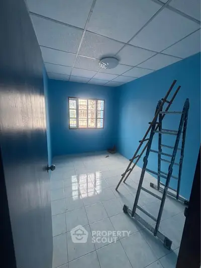 Bright blue room with ladder, ideal for renovation or customization.