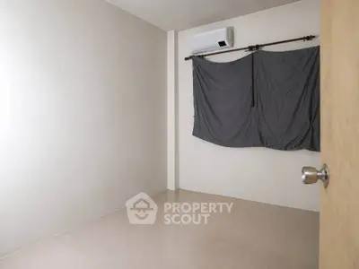 Minimalist empty room with air conditioning and curtain-covered window, ideal for customization.
