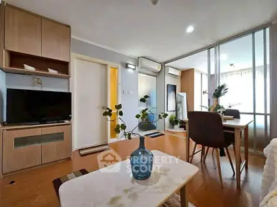 Modern living room with stylish decor and dining area, featuring wooden flooring and ample natural light.