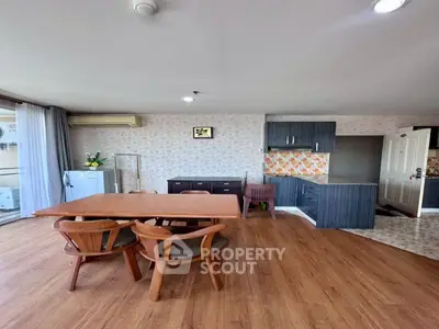 Spacious living room with wooden flooring and modern kitchen in open layout