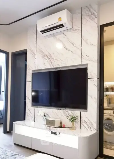 Modern living room with marble accent wall and mounted TV, featuring sleek air conditioning unit.