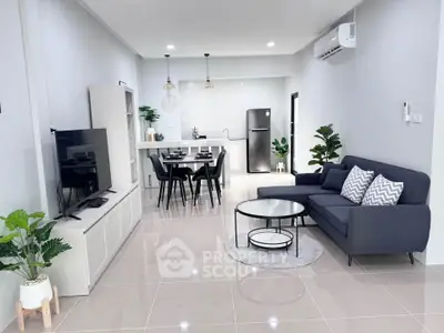 Modern open-plan living room with sleek furniture and stylish kitchen area, perfect for contemporary living.
