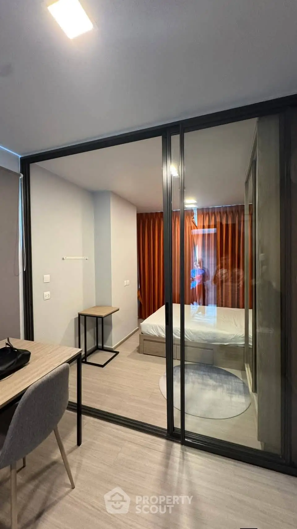 Modern bedroom with glass partition and stylish decor in a contemporary apartment.