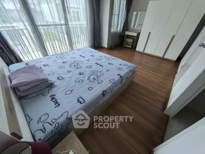 Spacious bedroom with large windows and modern furnishings, perfect for comfort and relaxation.