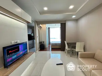 Modern living room with sleek furniture and built-in kitchen appliances, leading to a cozy balcony with natural light.