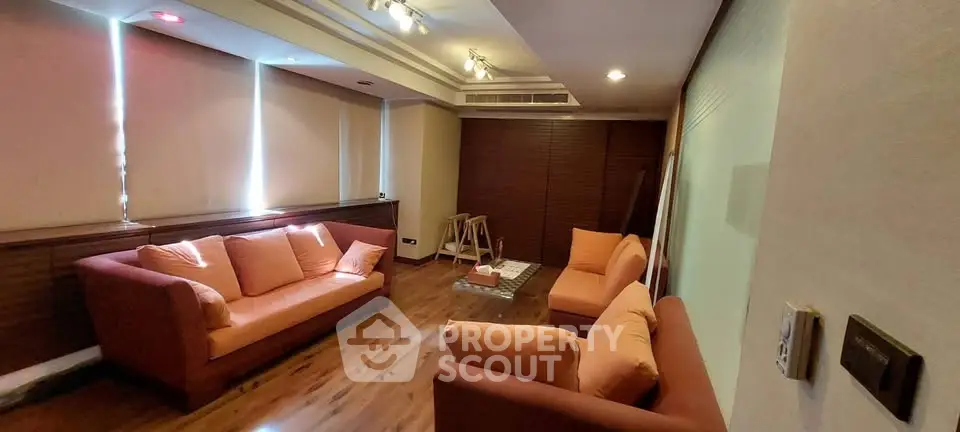 Spacious living room with modern decor and cozy seating in a stylish apartment.